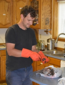 Alex begins the tedius work of plucking the feathers from a Grouse he shot on the property.